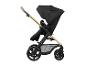 Schwarzer Kinderwagen mit goldfarbenem Gestell und braunem Griff