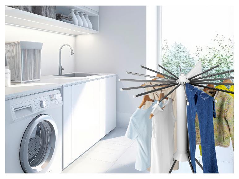 Waschküche mit Wäscheständer mit verschiedenen Kleidungsstücken, Waschmaschine und Spüle.