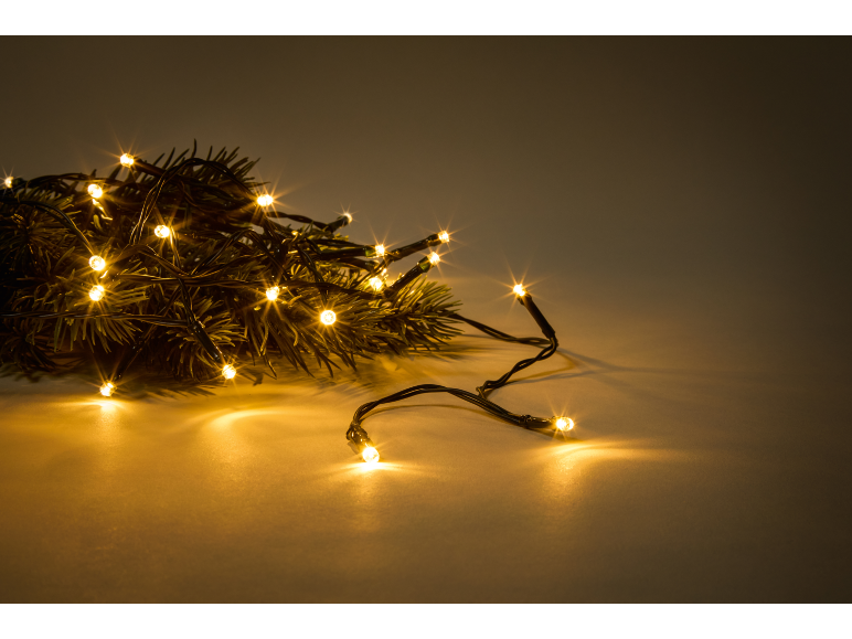 Goldene Weihnachtsbeleuchtung auf Tannenzweigen.