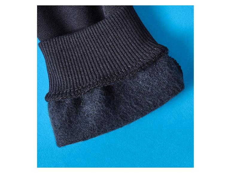 Nahaufnahme eines schwarzen Rippbündchens und gefütterten Stoffes auf blauem Hintergrund.