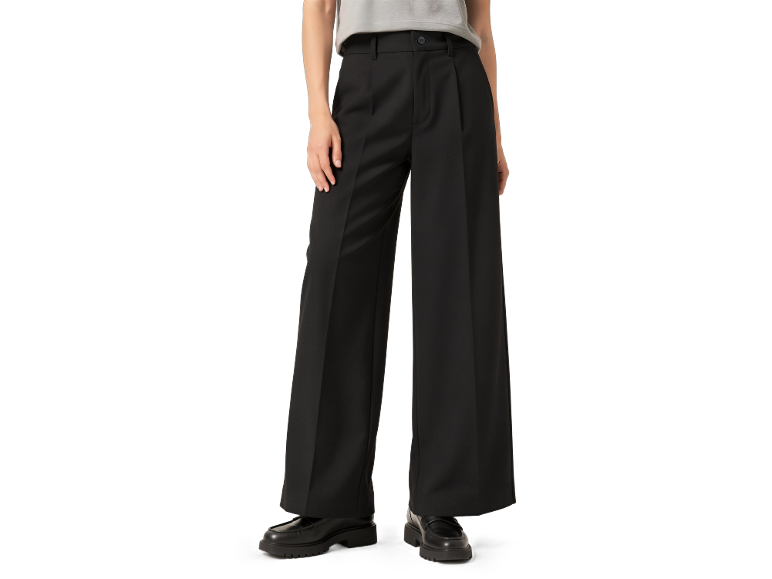 Schwarze weite Hose und graues T-Shirt, getragen mit schwarzen Mokassins.