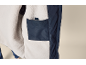 Innenseite einer dunkelblauen Jacke mit weichem, hellem Futter und einer Innentasche.