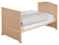 Ein Holz-Kinderbett mit Bettwäsche.
