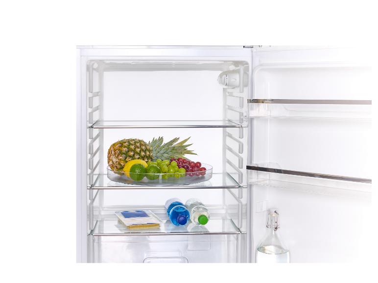 Offener Kühlschrank mit Obst, Wasserflaschen und Käse.