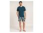 Mann in dunkelblauem T-Shirt und gestreiften Shorts.