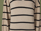 Beige gestreifter Pullover mit schwarzen Streifen.