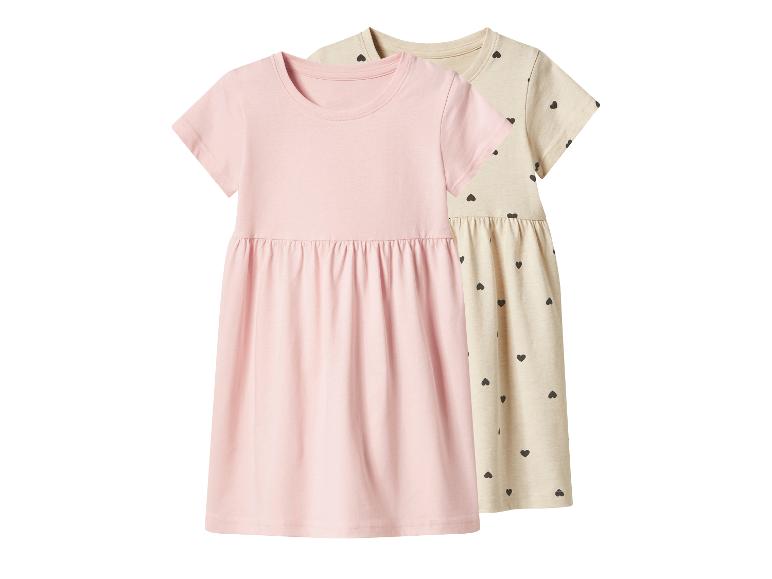 Rosa und beige Kinderkleider mit kurzen Ärmeln, das beige mit Herzmuster.