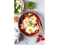 Shakshuka mit Feta, Eiern und Tomaten in einer Pfanne.