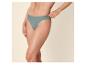 Frau in grünem Bikini-Slip, mit der Hand an der Taille.
