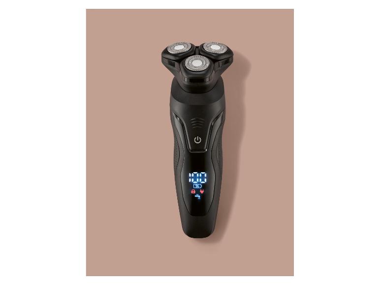 Schwarzer Rotationsrasierer mit Digitalanzeige auf hellbraunem Hintergrund.