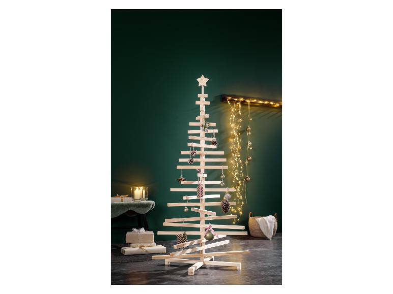 Ein moderner Holz-Weihnachtsbaum, geschmückt mit Ornamenten und Lichtern in einem festlichen Raum.