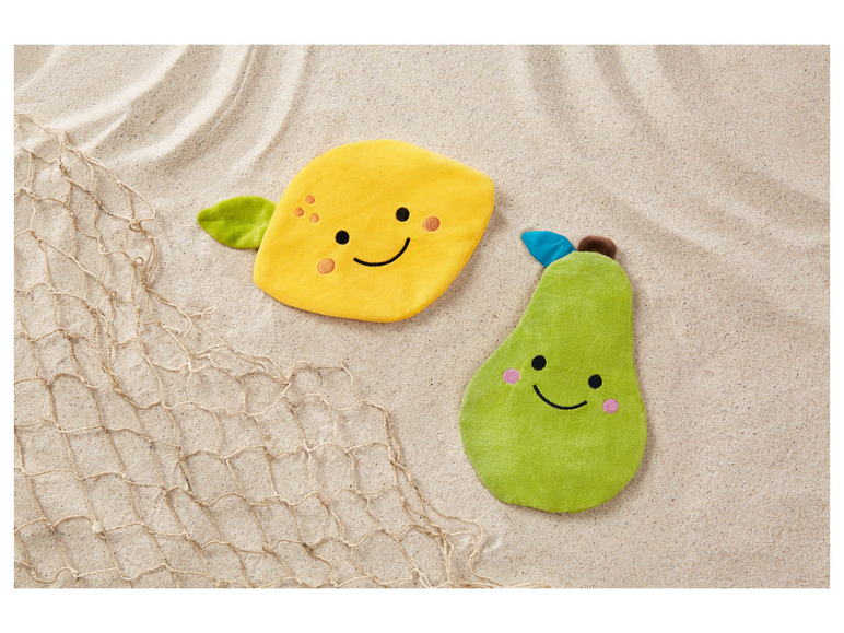 Eine gelbe Zitrone und eine grüne Birne, Plüschspielzeug auf Sand.