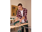 Mann benutzt ein Multifunktionswerkzeug zum Schaben von Holz, trägt Schutzbrille und Gehörschutz.
