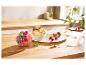 Zwei Schalen Eis mit Beeren, Macarons und Sternfrucht auf einem Holztisch.