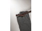 Graue Hose mit einem braunen Gürtel auf hellem Hintergrund.