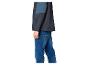 Mann in dunkelblauer und petrolfarbener Jacke mit blauen Jeans, Seitenansicht.
