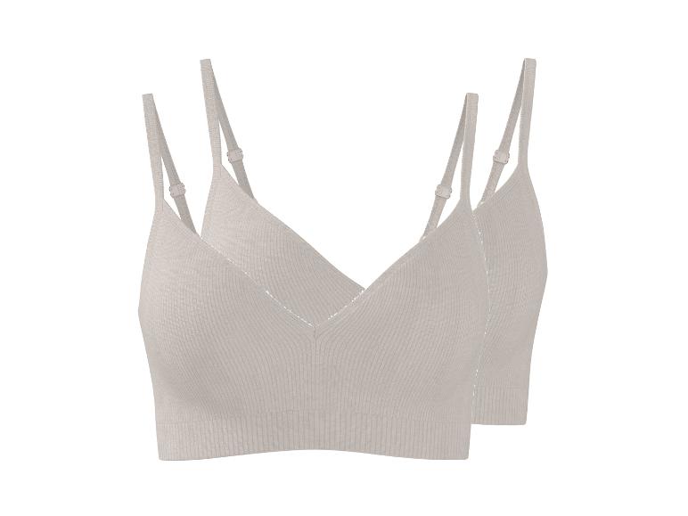 Zwei hellbeige gerippte Bralettes mit verstellbaren Trägern.