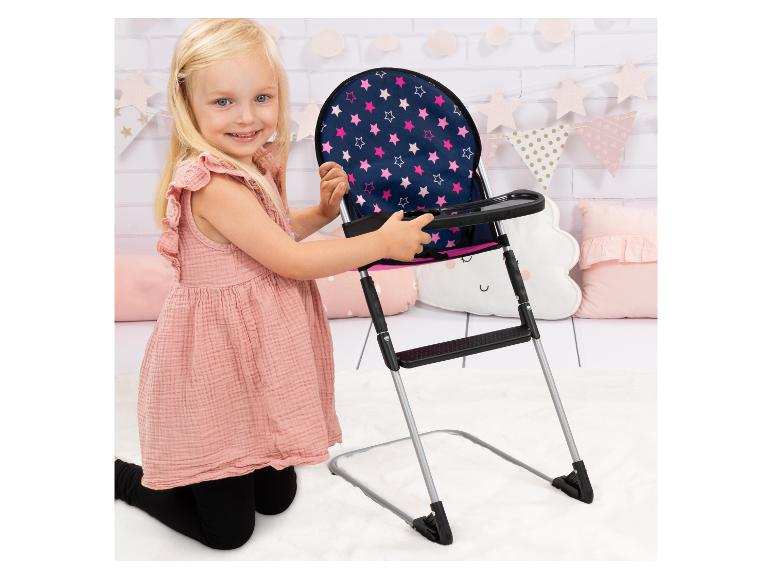 Lächelndes Mädchen mit einem Puppenhochstuhl mit Sternenmuster.