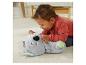 Baby spielt mit einem weichen Koala-Plüschtier auf einem cremefarbenen Teppich.