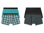 Zwei Paar Boxershorts: eine mit kariertem und eine mit gestreiftem Muster.