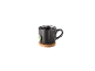 Dunkelgraue Tasse mit Tee auf einem Holzuntersetzer.