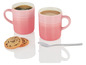 Zwei rosa Le Creuset Tassen mit Kaffee und zwei Kekse.