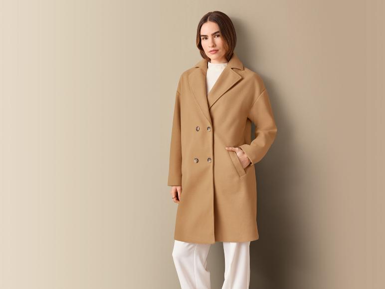 Eine Frau trägt einen beigefarbenen Wollmantel