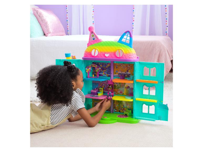 Mädchen spielt mit dem bunten Gabby's Dollhouse Celebration Puppenhaus.