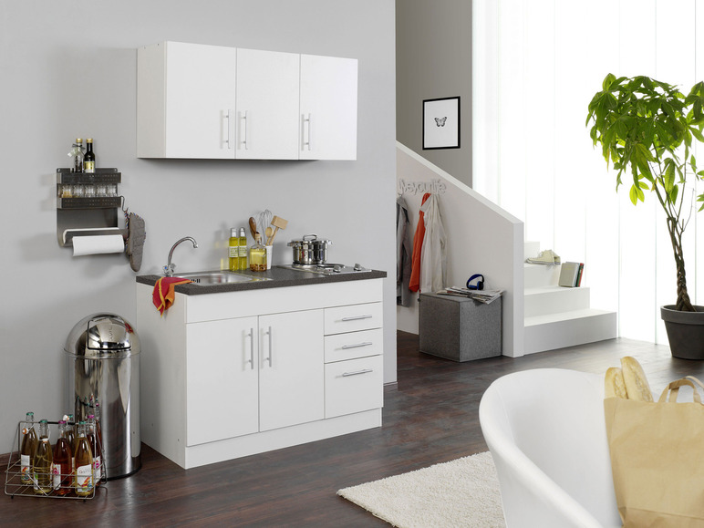 Weiße Küchenschränke mit Spüle und Mülleimer.