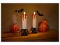 Halloween-Dekoration mit zwei blutenden Kerzen, Kürbissen, Fledermäusen und einem Geist.
