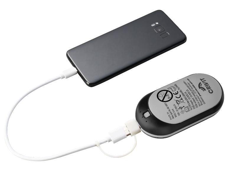 Ein schwarzes Smartphone wird von einer weißen und schwarzen Powerbank geladen.