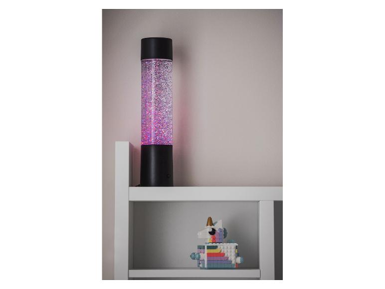 Glitzerlampe und ein farbenfrohes Einhornspielzeug auf einem weißen Regal.