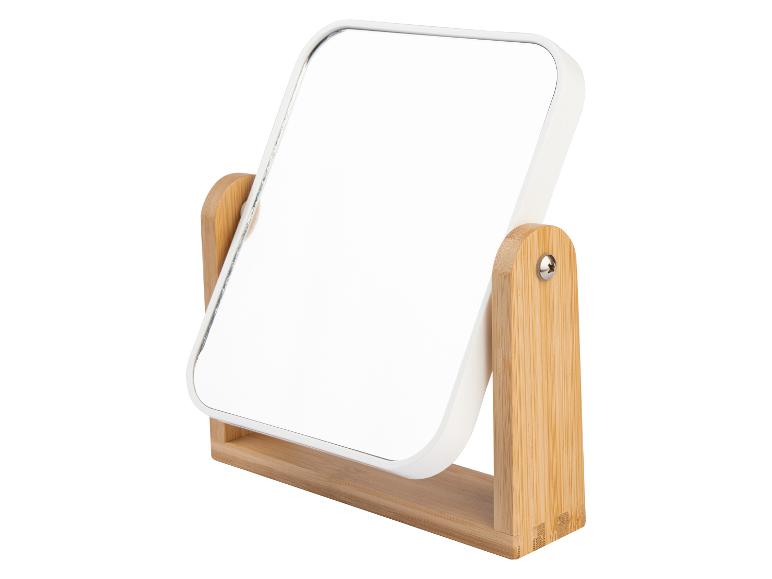 Ein weißer Schminkspiegel mit einem Holzständer