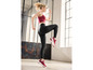 Eine Frau in schwarzen Leggings und roten Sneakern trainiert.