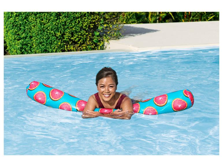 Eine Frau entspannt sich auf einer Pool-Liege mit Grapefruit-Muster.