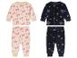 Zwei Kinderpyjamas: einer mit Tannenbaum-Muster, der andere mit Schneeflocken.