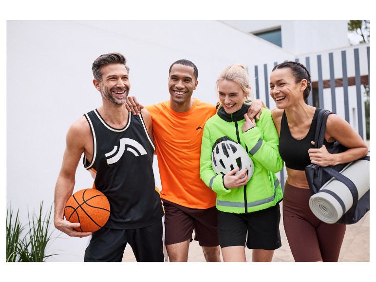 Vier lächelnde Freunde in Sportkleidung, bereit zum Training.