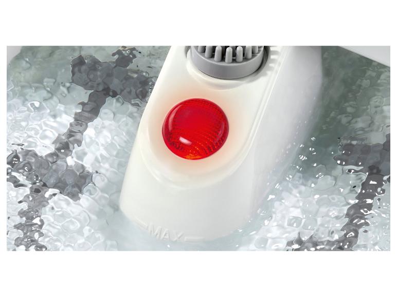 Ein rotes Licht leuchtet die Schalttafel eines Fußspas an, der teilweise im Wasser liegt.