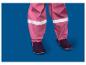 Rosa Kinder-Regenhose mit reflektierenden Streifen und dunklen Stiefeln.