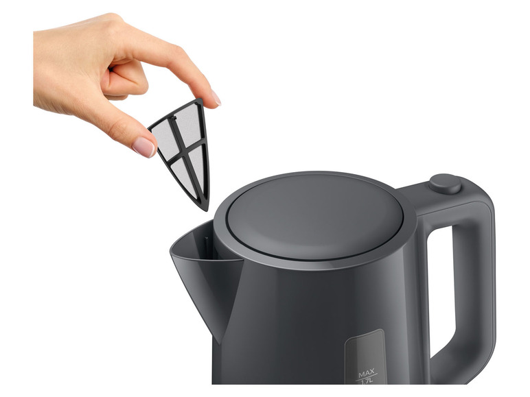 Eine Hand entfernt einen Filter aus einem grauen Wasserkocher.