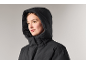 Frau mit der Kapuze einer schwarzen Winterjacke auf dem Kopf.