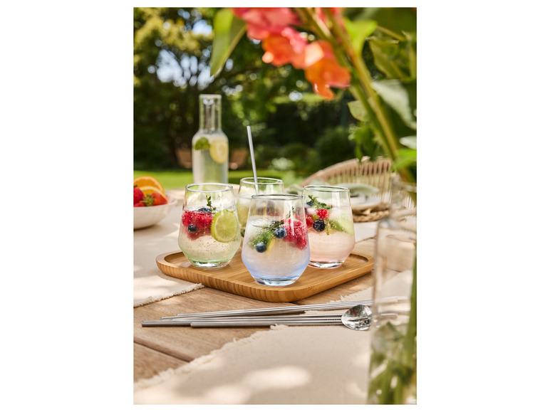 Gläser mit Obst und Eiswürfeln auf einem Holztablett.