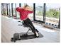 Frau trainiert auf einem Bauchtrainer mit Hanteln in einem hellen Raum.