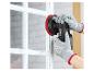 Behandschuhte Hände schleifen einen weißen Fensterrahmen mit einem Akku-Schleifer.