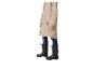 Person in beigem Regenmantel, Jeans und schwarzen Gummistiefeln.