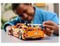 Ein Kind baut ein orangefarbenes LEGO Technic Fast & Furious Auto zusammen.