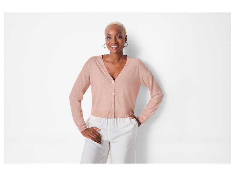Model mit rosa Cardigan und weißer Hose.