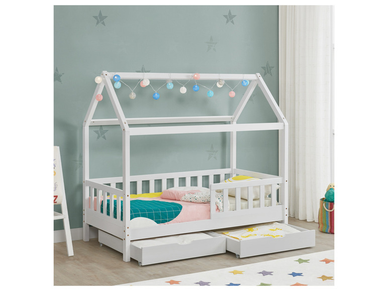 Ein weißes Holz-Hausbett mit zwei Schubladen und Lichterkette