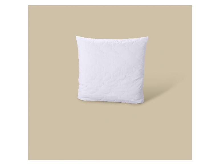 Weißes gestepptes Kissen auf beigem Hintergrund