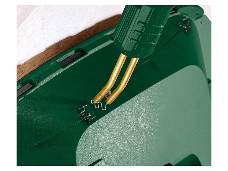 Nahaufnahme eines grünen Kunststoffschweißgeräts mit Metallklammern, die einen Riss reparieren.